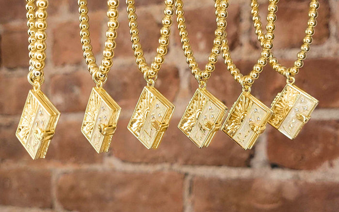 Trust, Seek, Believe, Faith, Peace, and Love Secret Scripture Lockets lined up in front of a brick wall
